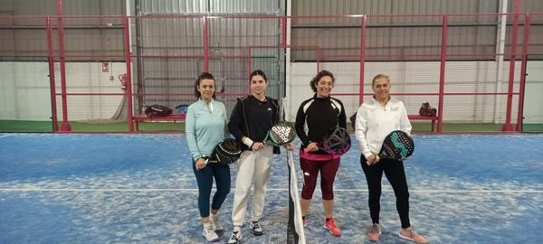 Cuatro jugadoras posan junto a la red en una de las pistas del club