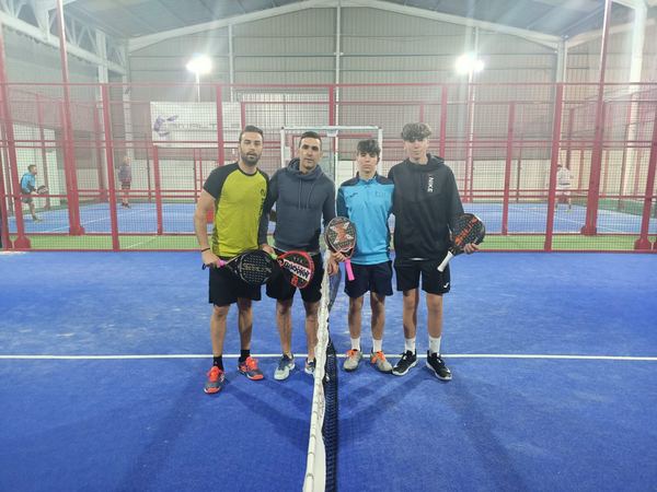 Cuatro jugadores posan en la pista con la red de fondo