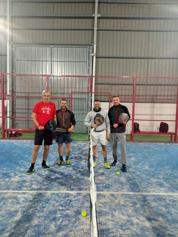 Grupo de jugadores posando en la pista tras un partido